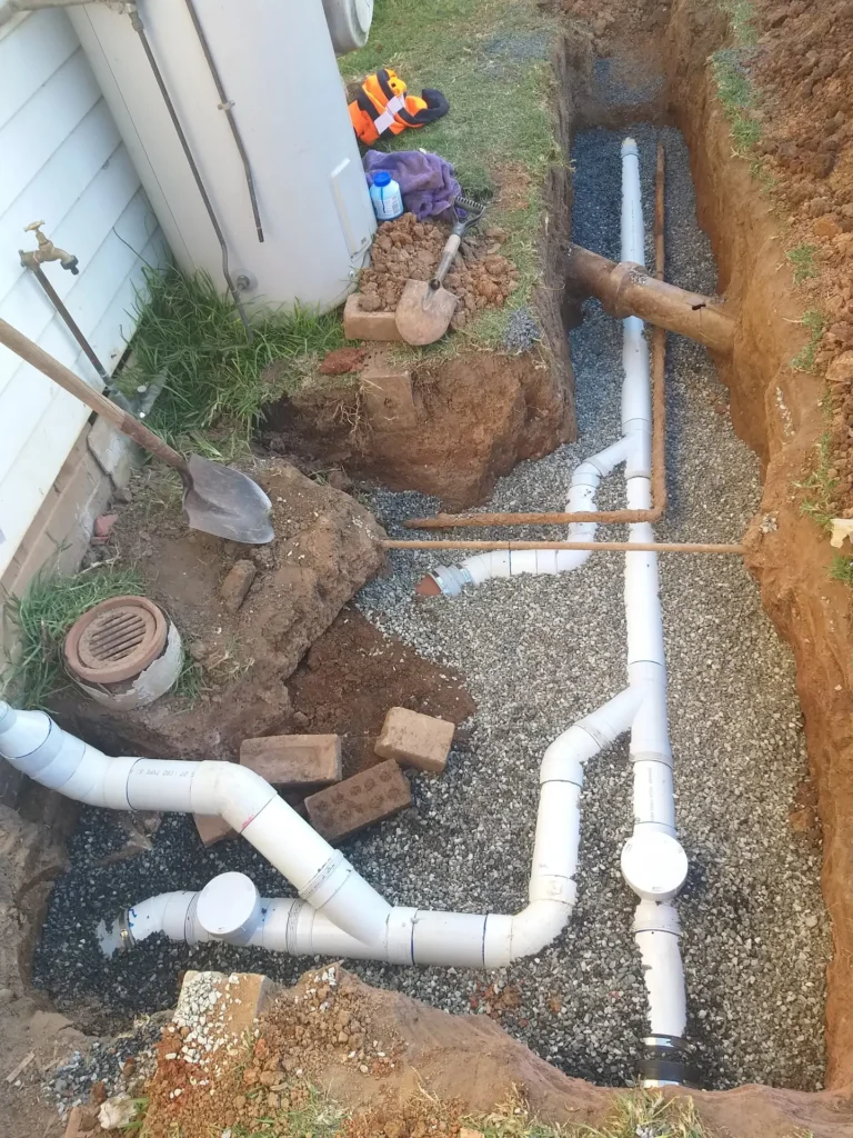 A septic system with a sewer pipe being installed in a yard.